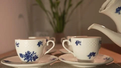 Pouring Tea into an Elegant Porcelain Cup Stockbeeldmateriaal 338186358