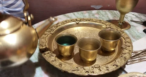 Pouring tea from gold teapot into small gold luxury cup. Stock Footage 113767404