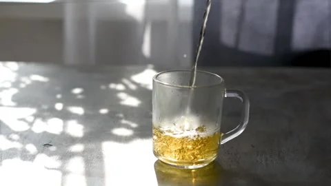 Pouring tea. Hot tea is poured into a glass transparent cup Stock Footage 154243533