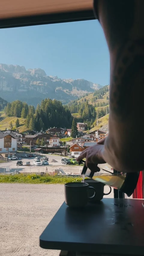 Pouring Tea Inside Camper Van with Italian Mountain Town View Stock Footage 330120921