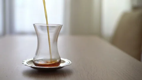 Pouring tea out of tea pot in a classical traditional turkish tea glass Stock Footage 129421258