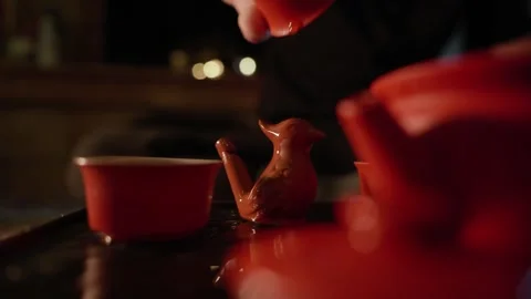 Pouring Tea Over Bird-Shaped Tea Figurine Stock Footage 321933233