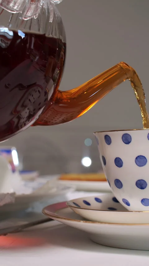 Pouring Tea into Polka Dot Cup on Stacked Saucers Stock Footage 282363128