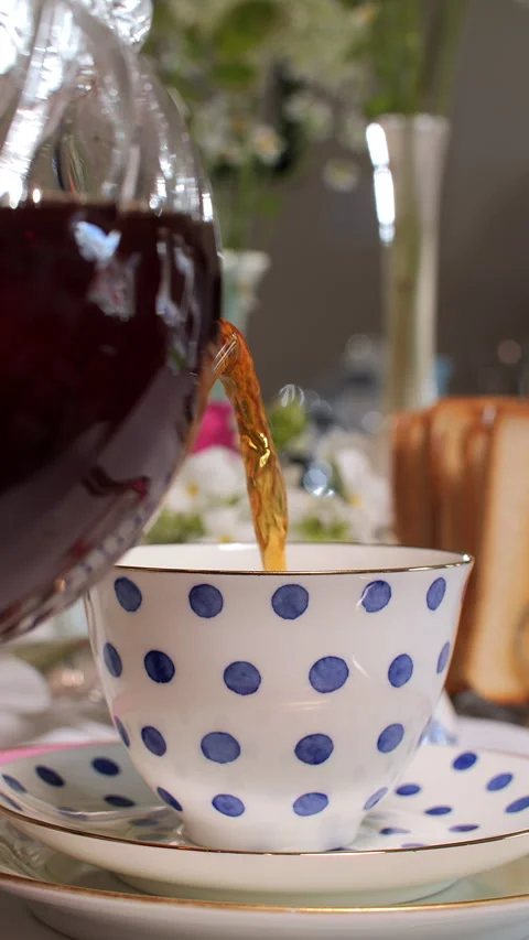 Pouring Tea into Polka Dot Cup on Stacked Saucers Stock Footage 282363334