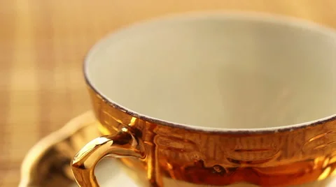 Pouring tea into the porcelane cup from kettle Video stock 47694946