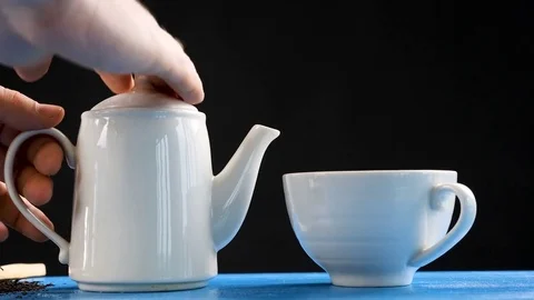 Pouring tea in slow motion from a kettle in a cup Stock Footage 84949609