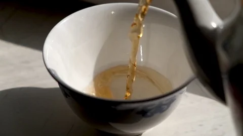 Pouring tea into the tea bowl. Closeup Stock Footage 107920864