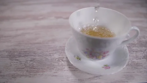 Pouring tea into tea cup slow motion Stock Footage 147446999