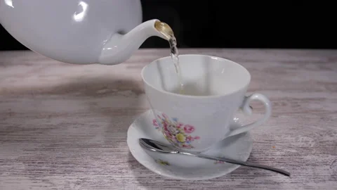 Pouring tea from tea pot into tea cup 4k Stock-Footage 147419057
