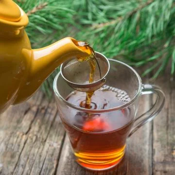 Pouring tea in white cup, rustic wood background Stock Photos