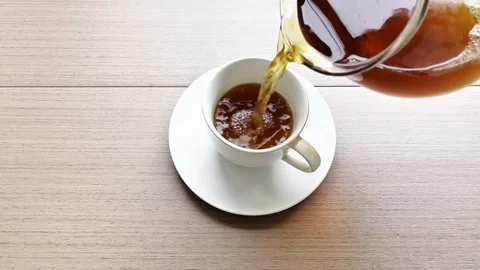 Pouring tea into a white cup, viewed from above. Stock Footage 338343349