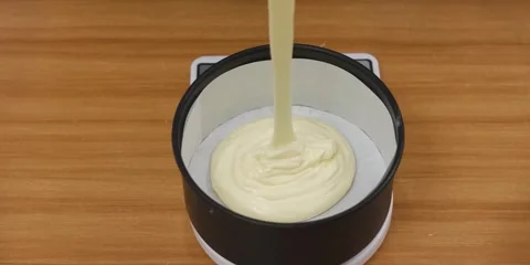 Pouring Thick Cake Batter into a Round Baking Pan with Parchment Paper Stock Footage 343588349