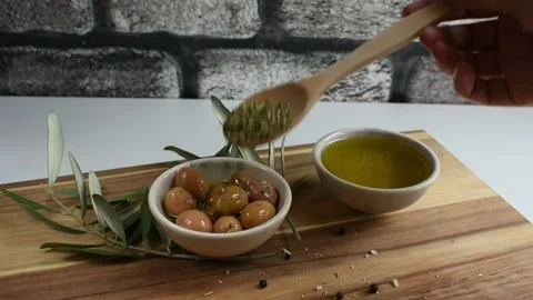 Pouring thyme on green olives Stock Footage 143780642