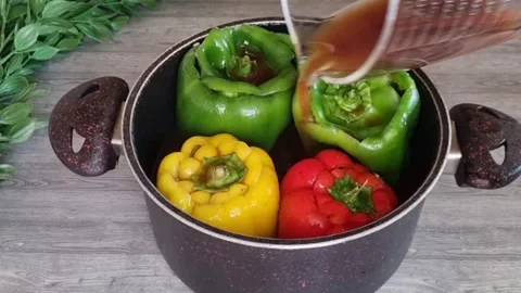 Pouring Tomato Sauce Over Stuffed Bell Peppers in Pot - HD Stock Footage Stock Footage 343869628