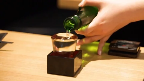 Pouring  traditional japanese sake in to a glass in a japanese bar Stock Footage