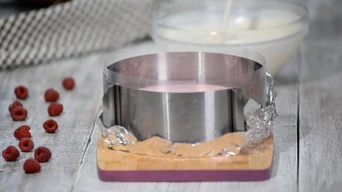Pouring vanilla mousse. Making raspberry cream mousse cake. Raspberry cake Stock Footage 98582349