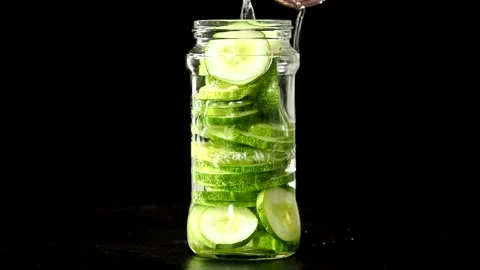 Pouring vinegar in cucumbers bottle  to make pickled cucumbers , in door  Chiang Stock Footage 247421137