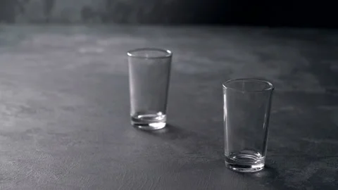 Pouring vodka in glasses close-up. Vodka being poured into a glass Stock Footage 98973632