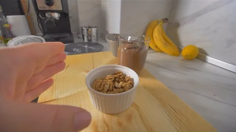 Pouring walnuts in a heated pan. Making American pancakes Stock Footage 113058477