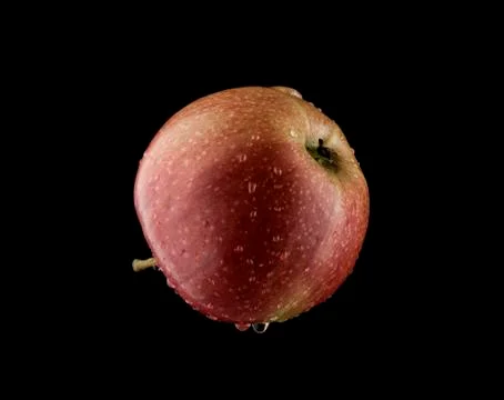 Pouring water on an apple Stock Photos