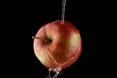 Pouring water on an apple Stock Photos