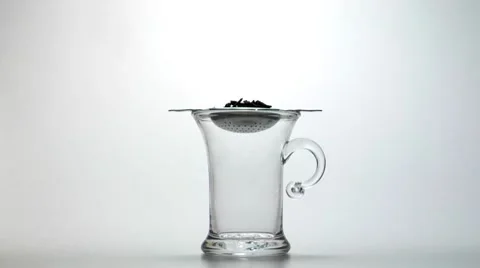 Pouring water onto black tea in strainer Stock Footage 8572981