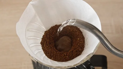 Pouring water into coffee filter bloom phase Stock Footage 120995247