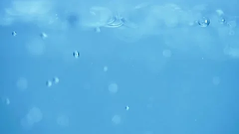 Pouring water creates a splash and then bubbles floating to the surface. Stock-Footage 239766094