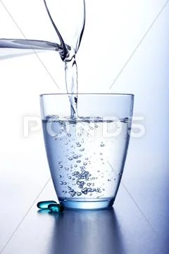 Pouring Water Into a Glass From a Pitcher Stock Photos