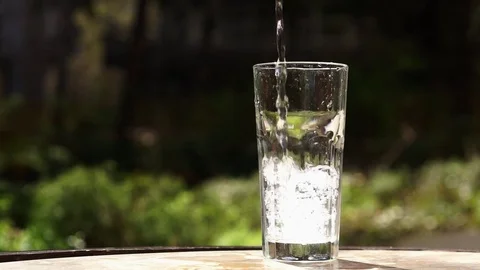 Pouring water into glass placed on table. 動画素材 73776216