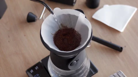Pouring water over ground coffee in filter, brewing drip coffee Stock Footage 337403025