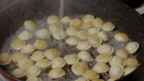 Pouring water in pan with fried mini dumplings Stock-Footage 243187713