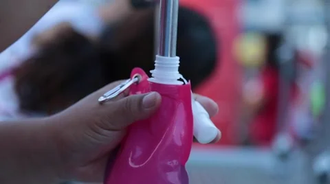 Pouring water into pink bottle Stock Footage 51891346