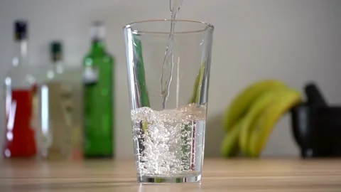 Pouring water in slow motion with elements in the background Video stock 132249604