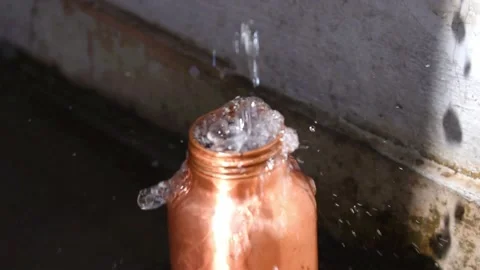 Pouring water from tap into copper bottle , copper water for healthy life Stock Footage 152302969