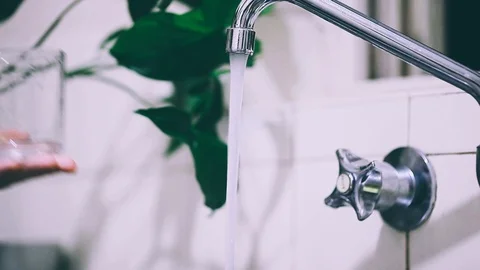 Pouring water from the tap. Cup with tap water. Drinking water from the tap Stock Footage