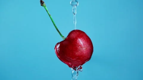 Pouring water from the top over a cherry in Slow Motion 1000fps Stockbeeldmateriaal 330532941