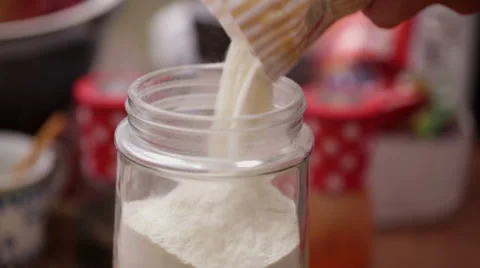 Pouring wheat flour from paper bag to jar - closeup Stock Footage 44728034