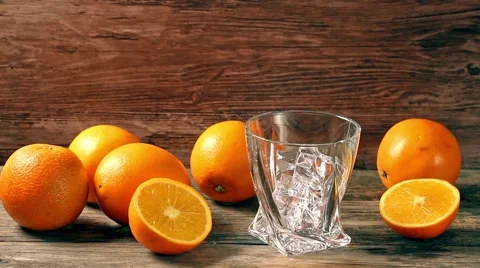 Pouring whiskey from bottle to glass over gray background with orange Stock Footage 59163542
