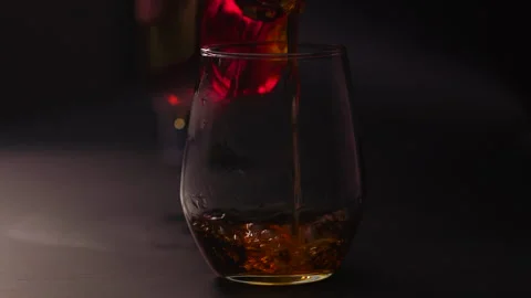 Pouring whiskey into an empty glass Stock Footage 252424350