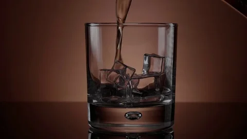 Pouring Whiskey in a glass with ice - beautiful slow motion shot Stock Footage