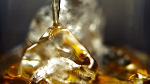 Pouring Whiskey on Ice in glass Stock Footage