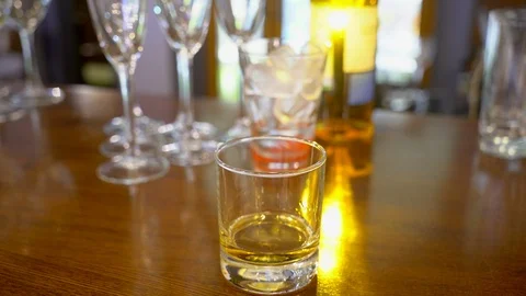 Pouring whisky from the bottle on black background. Glass of rum alcohol Stock Footage 101323314