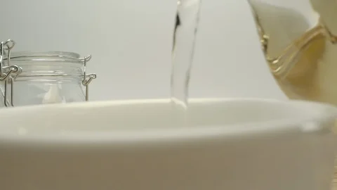 Pouring white authentic tea into classical white cup on wooden table Stock Footage 130051448