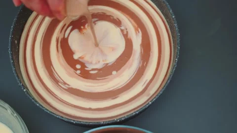 Pouring white cream into chocolate mixture in kitchen overhead view Vidéo 342879793