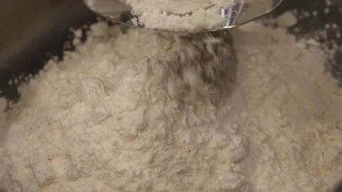 Pouring white flour into a bowl for baking. Video stock 345291410