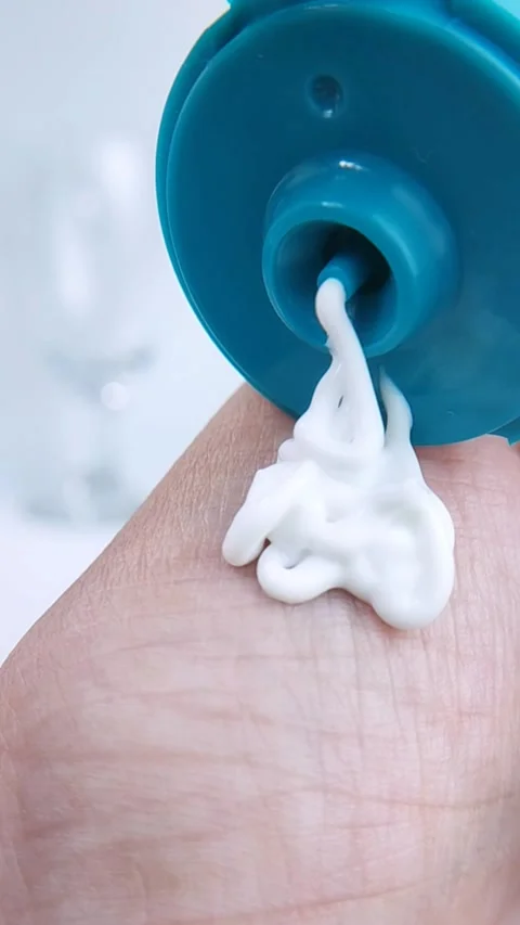 Pouring white moisturizing cream onto hand skin. Clean and healthy skincare.. Stock Footage 331255151