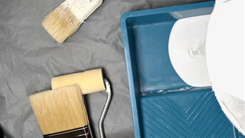 Pouring white paint into tray Stock Footage 254598939