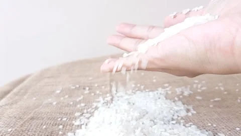 Pouring white rice into a brown table Stock Footage 145622940