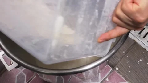 Pouring White Wheat Flour into a Stainless Steel Mixing Bowl for Baking Stock Footage 331632455